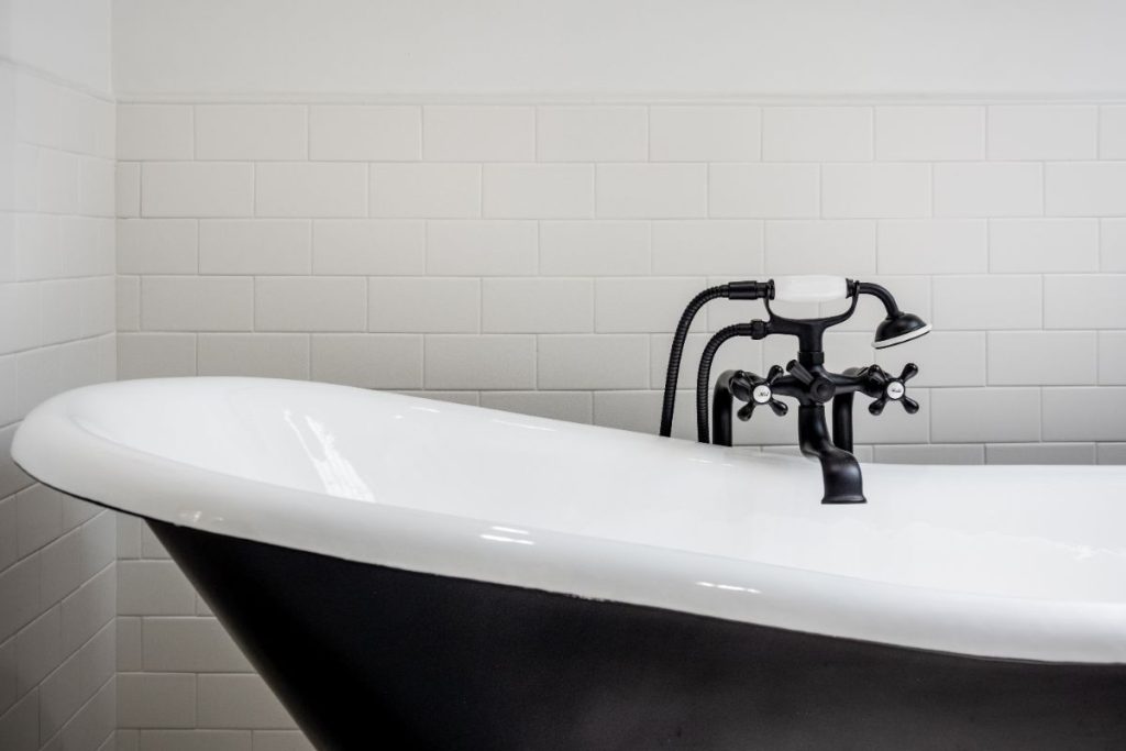 close-up of a black-and-white clawfoot bathtub with matte black fixtures in a remodeled bathroom in Chapel Hill, North Carolina