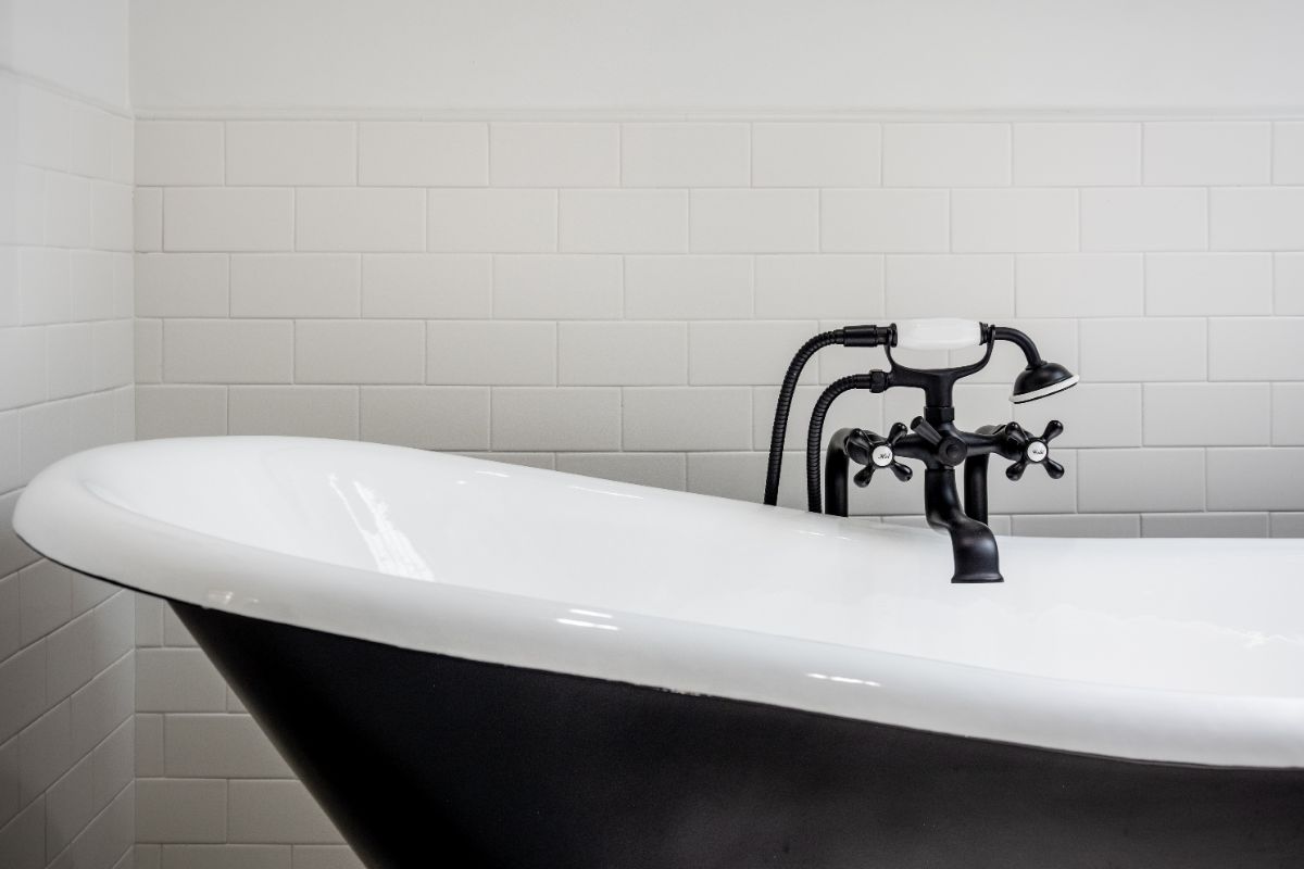 close-up of a black-and-white clawfoot bathtub with matte black fixtures in a remodeled bathroom in Chapel Hill, North Carolina
